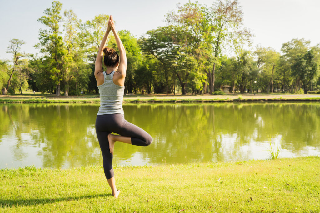 Young asian woman yoga outdoors keep calm and meditates while pr