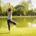 Young asian woman yoga outdoors keep calm and meditates while pr